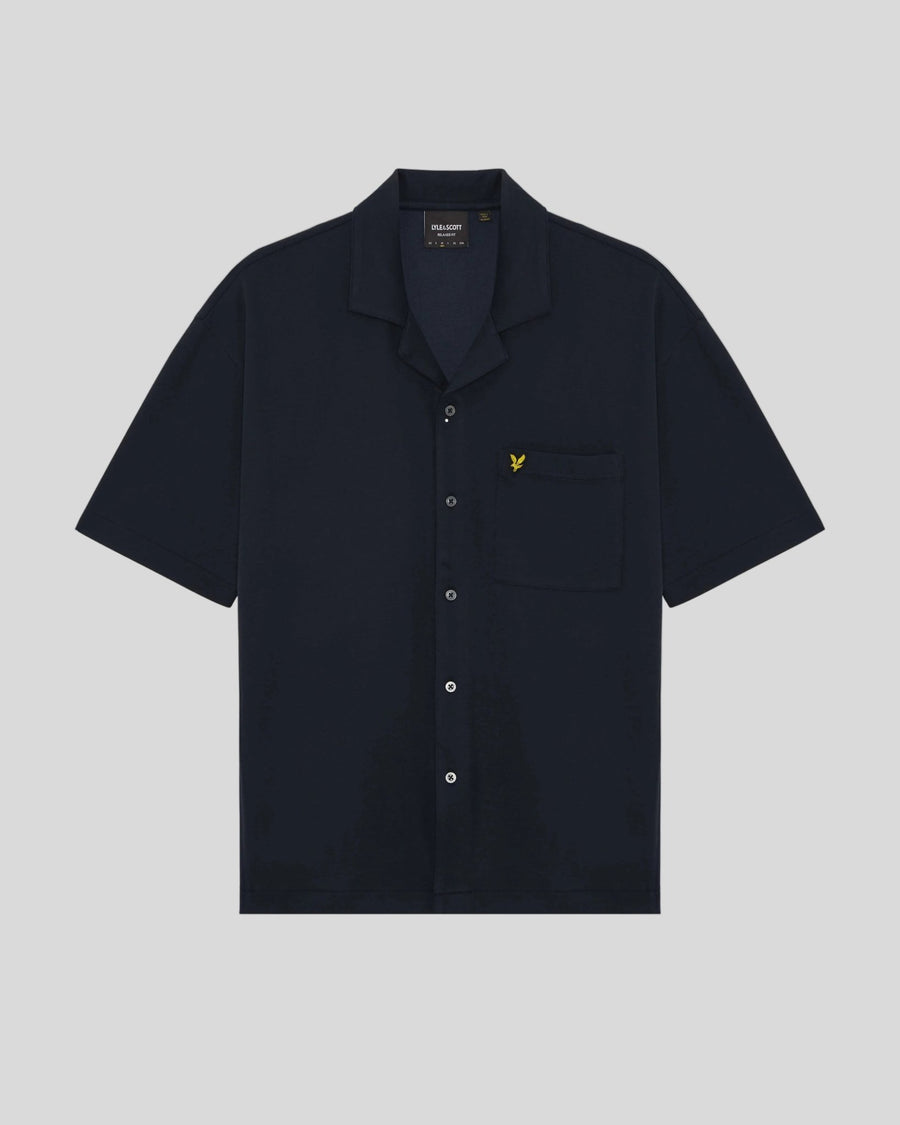 Un homme porte une chemise à manches courtes et col revers, de couleur bleu marine foncé