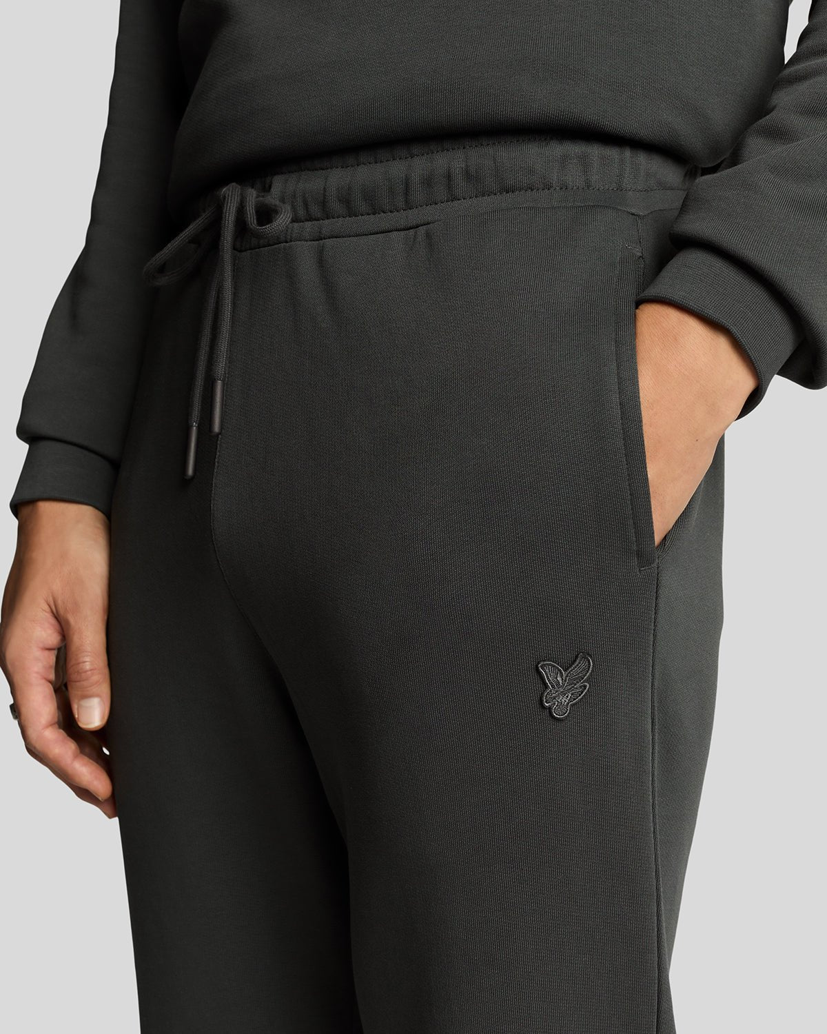 Un homme porte un pantalon de jogging slim en coton ultra-fin, couleur gris métallisé
