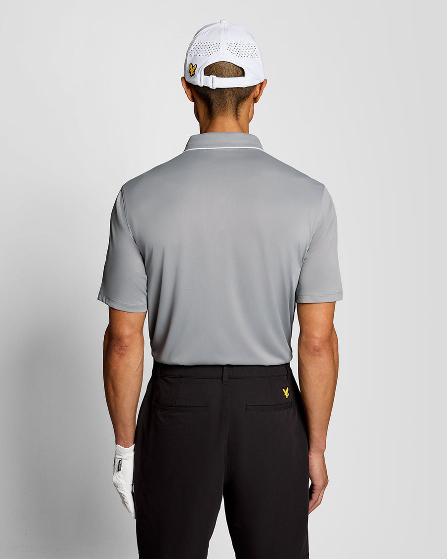 Un homme porte un polo à col contrasté de couleur « Ultimate Grey »