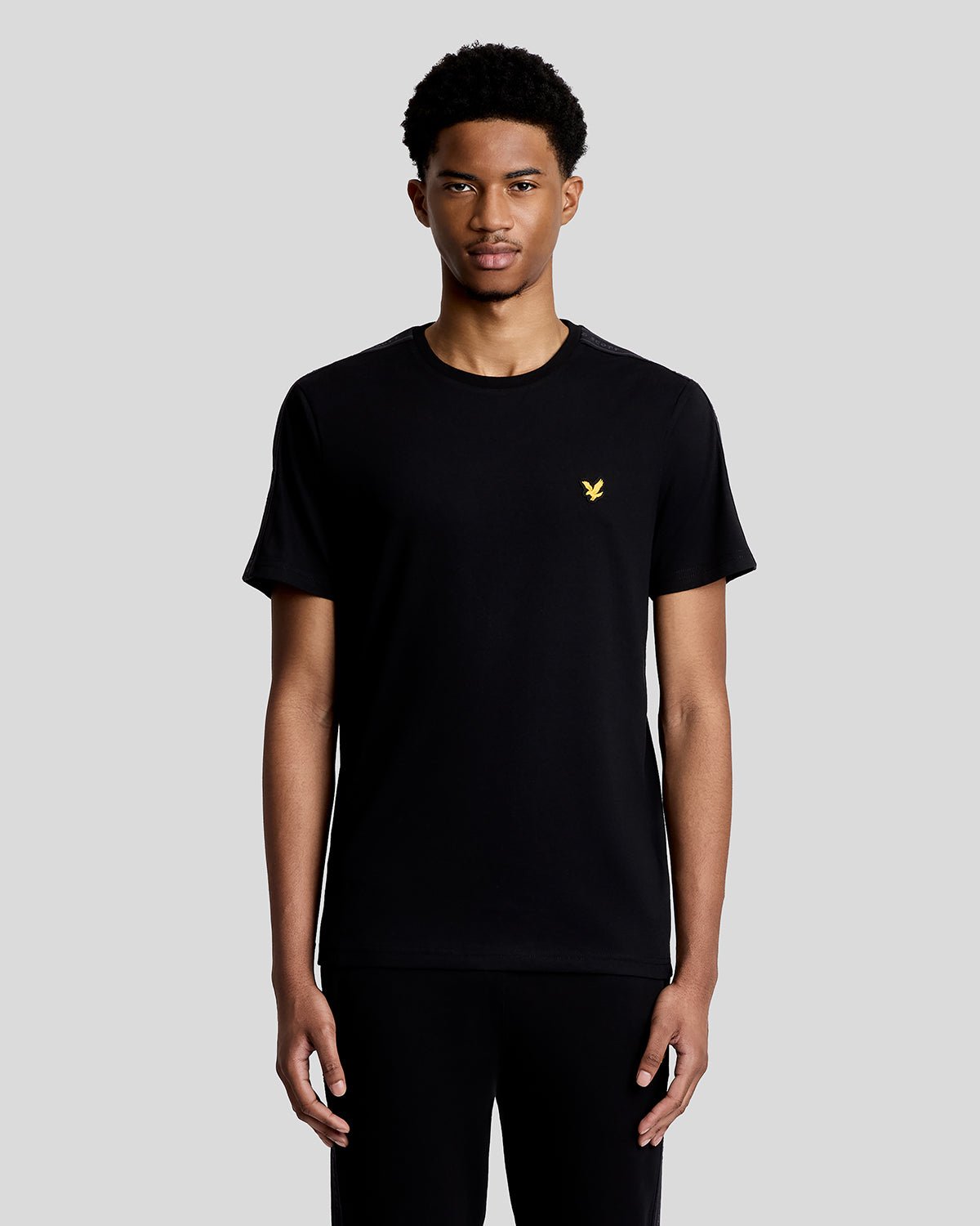 Hombre lleva camiseta deportiva con cinta jacquard en color negro azabache.