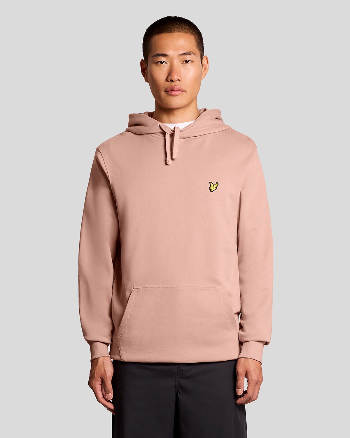 L'uomo indossa una felpa con cappuccio Loopback in cotone color rosa pompelmo