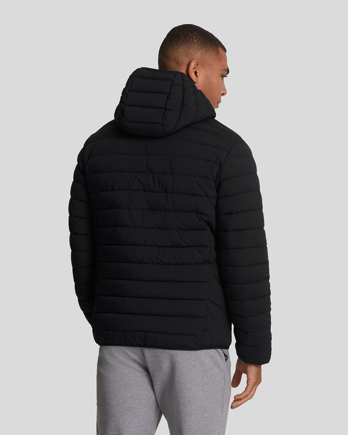 Man wears Sports Water Resistant Puffer Jacket in Jet Black