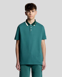 Man wears Tipped Logo Polo Shirt in Everglade