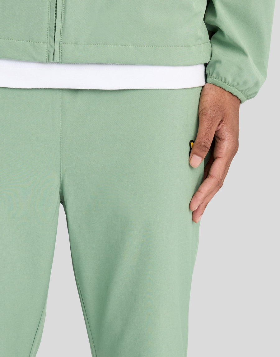 Man bär träningsbyxor med paneler i färgerna Botanical Green/Cactus Green
