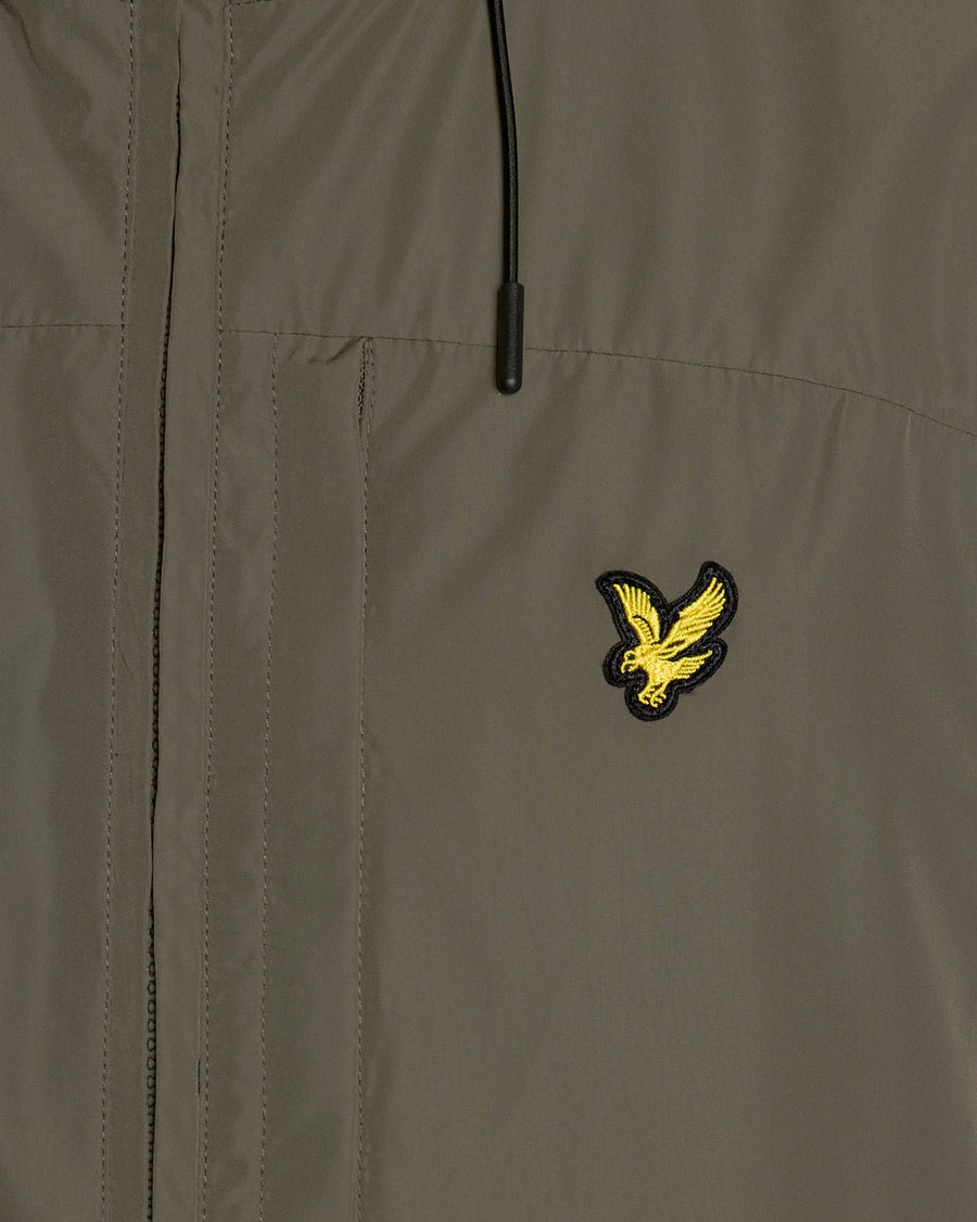 Un homme porte une veste à capuche légère de couleur kaki cendré