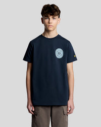 Man wears Graphic Badge Cotton T-Shirt in Dark Navy