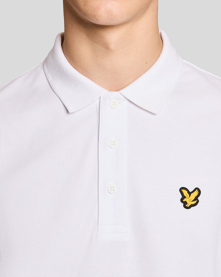 Un homme porte un polo de sport blanc