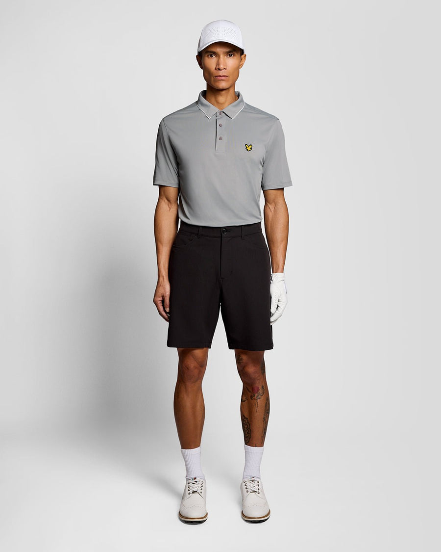 Un homme porte un polo à col contrasté de couleur « Ultimate Grey »