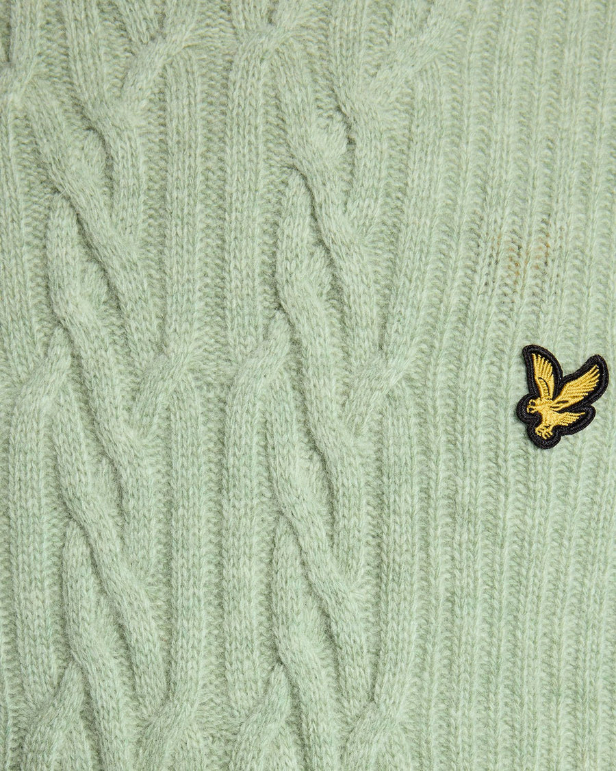 Un homme porte un pull en maille torsadée côtelée, couleur « Cold Mint Marl »