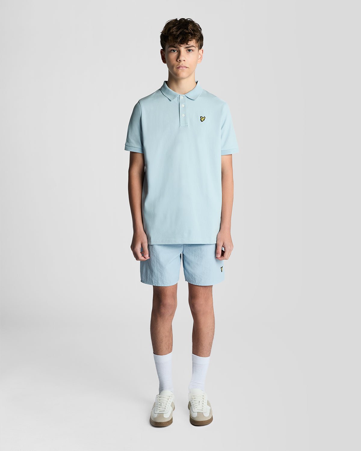 Un homme porte un polo en coton bleu opale