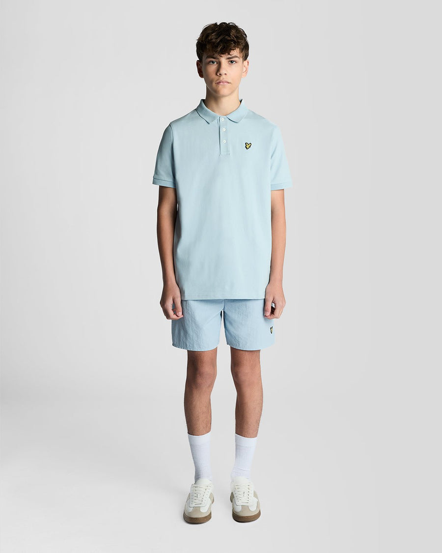 Un homme porte un polo en coton bleu opale