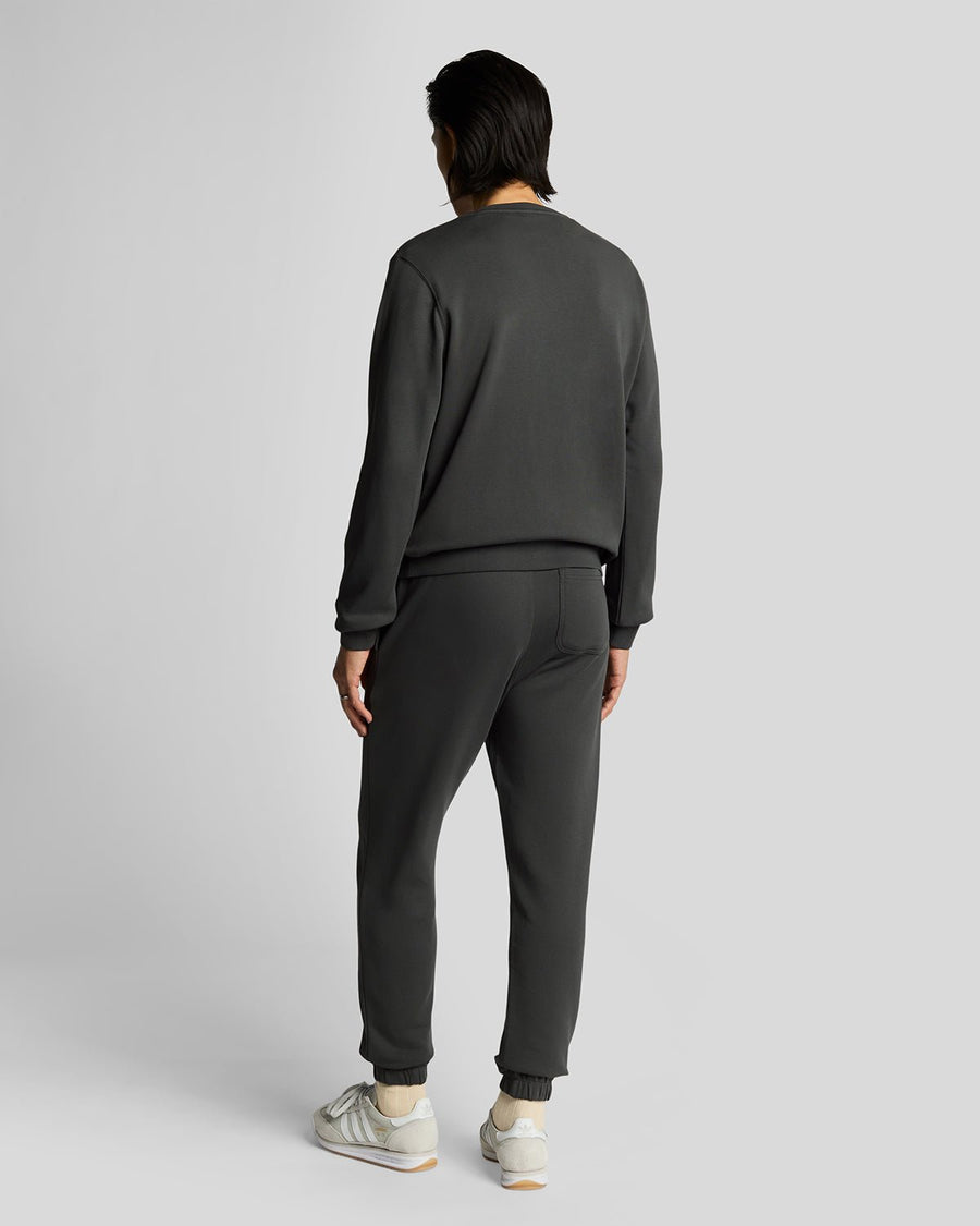 Un homme porte un pantalon de jogging slim en coton ultra-fin, couleur gris métallisé