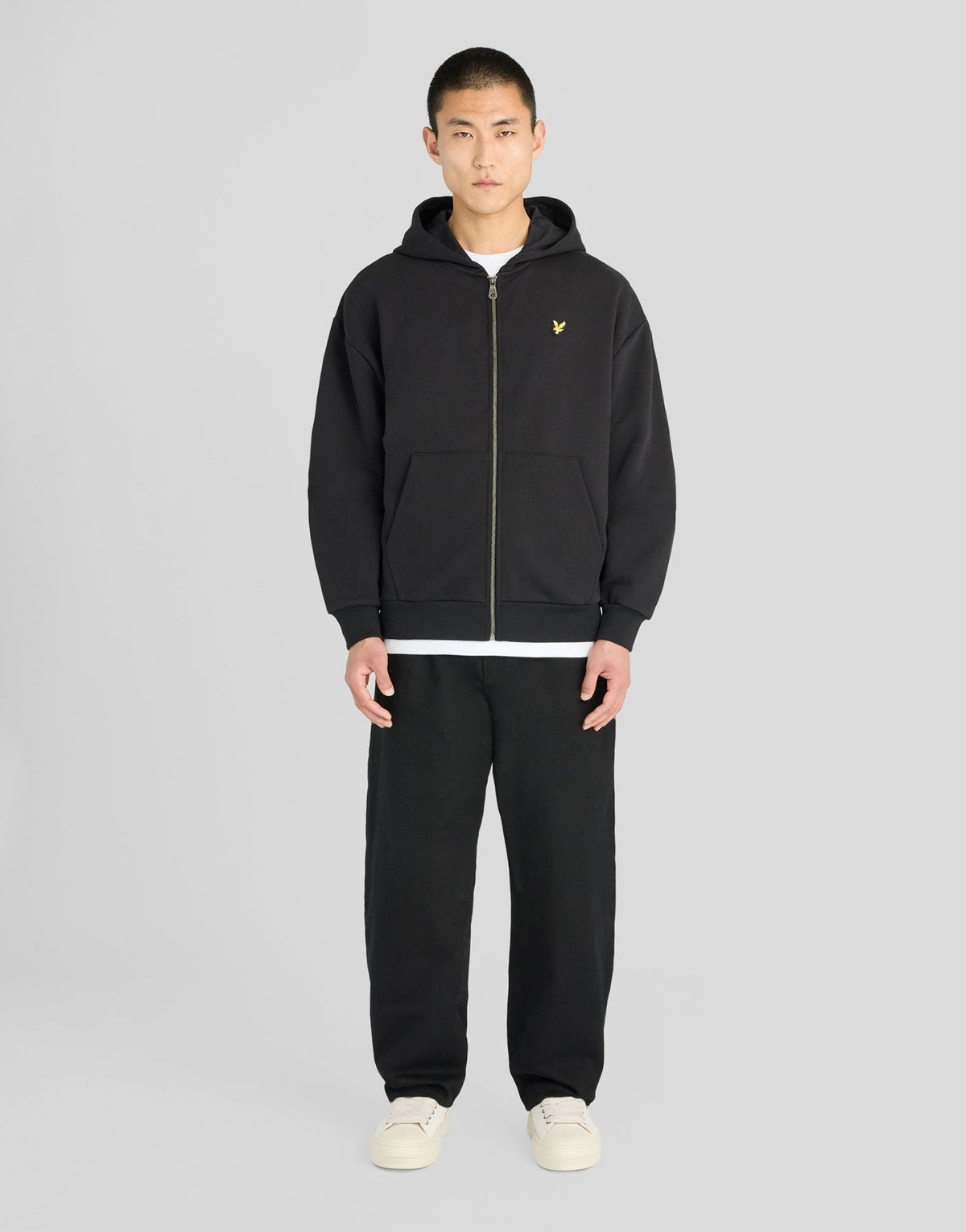 Man wears Heavyweight Loopback Zip Hoodie in Jet Black