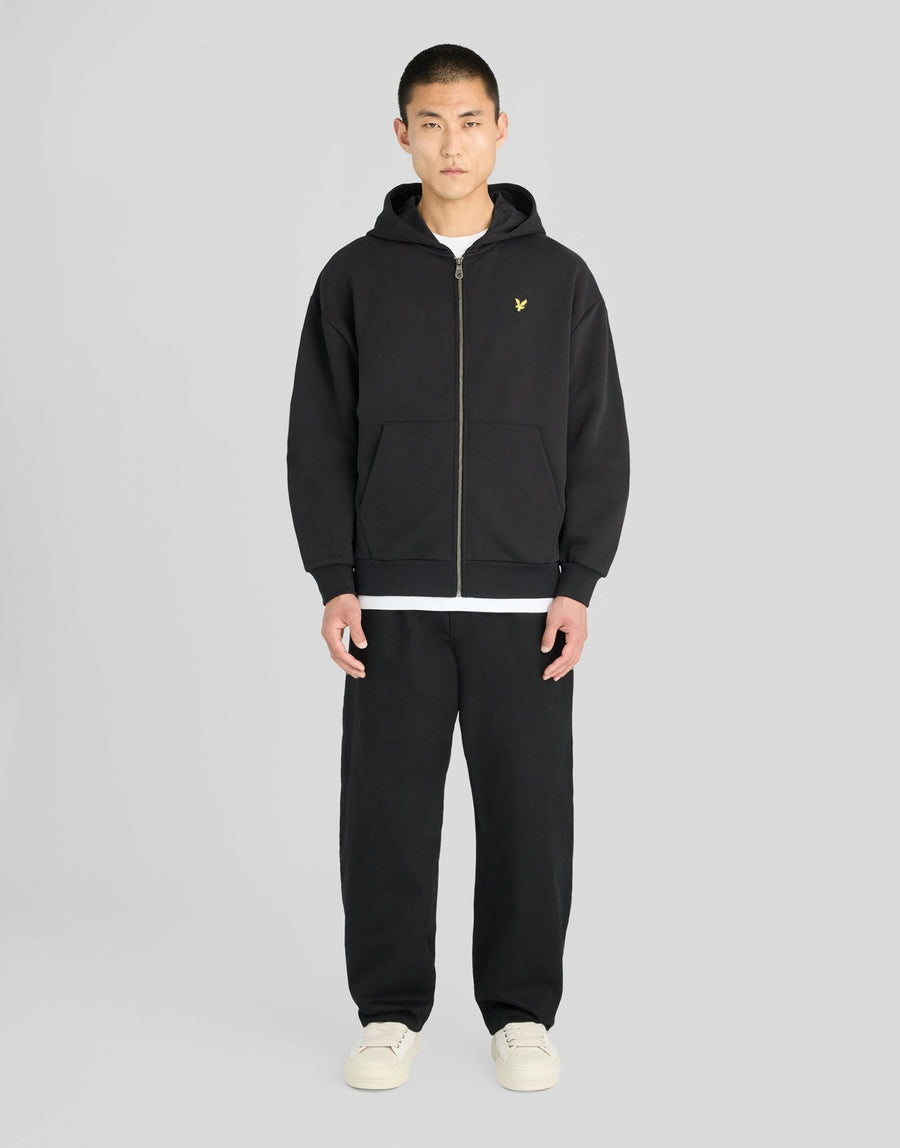 Man wears Heavyweight Loopback Zip Hoodie in Jet Black