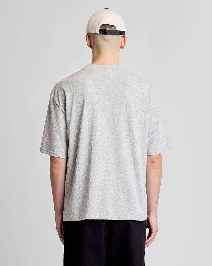 Un homme porte une casquette à patch Wavey Garms de couleur crème