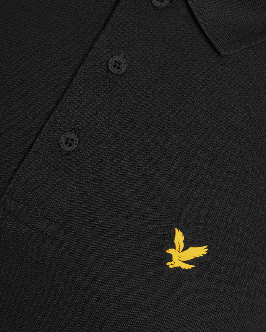 Un homme porte un polo technique noir de jais