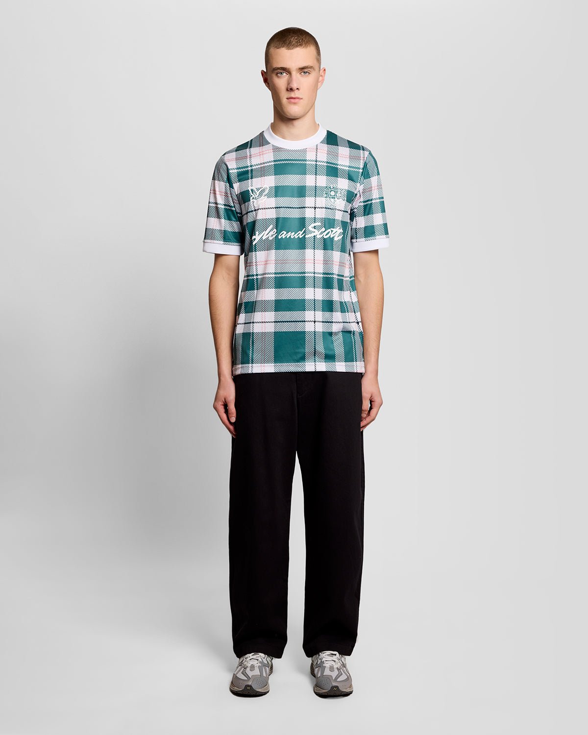 Un homme porte un maillot de football à carreaux tartan de sport, couleur Everglade