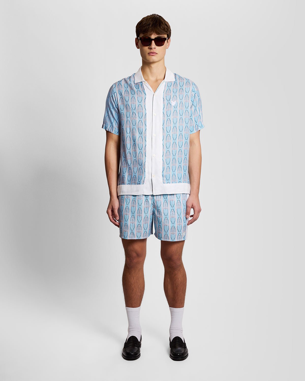 Homme portant un short de bain à motifs floraux, couleur crème amande/bleu de Parme