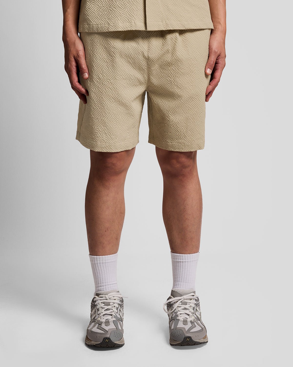 Un homme porte un short de plage texturé couleur Savona Clay
