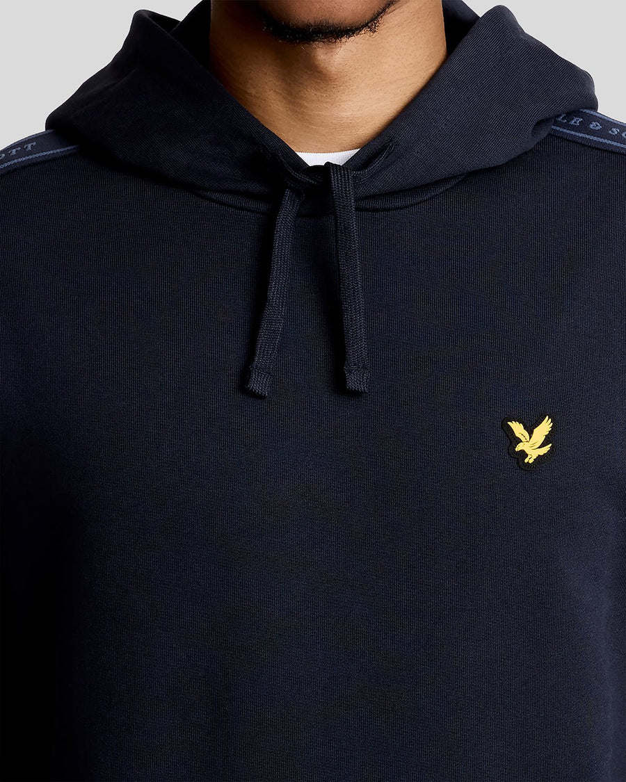 Hombre lleva sudadera con capucha Sports Tape de mezcla de algodón en azul marino oscuro.