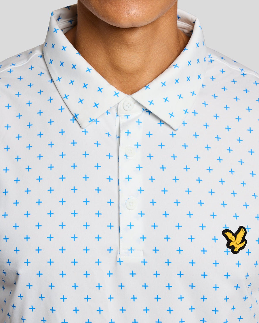 Un homme porte un polo blanc à motif croix