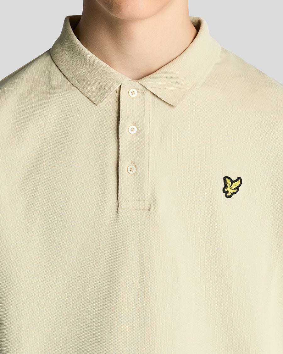 Un homme porte un polo en coton couleur blé