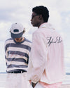 Two people wearing branded clothing with a scenic background